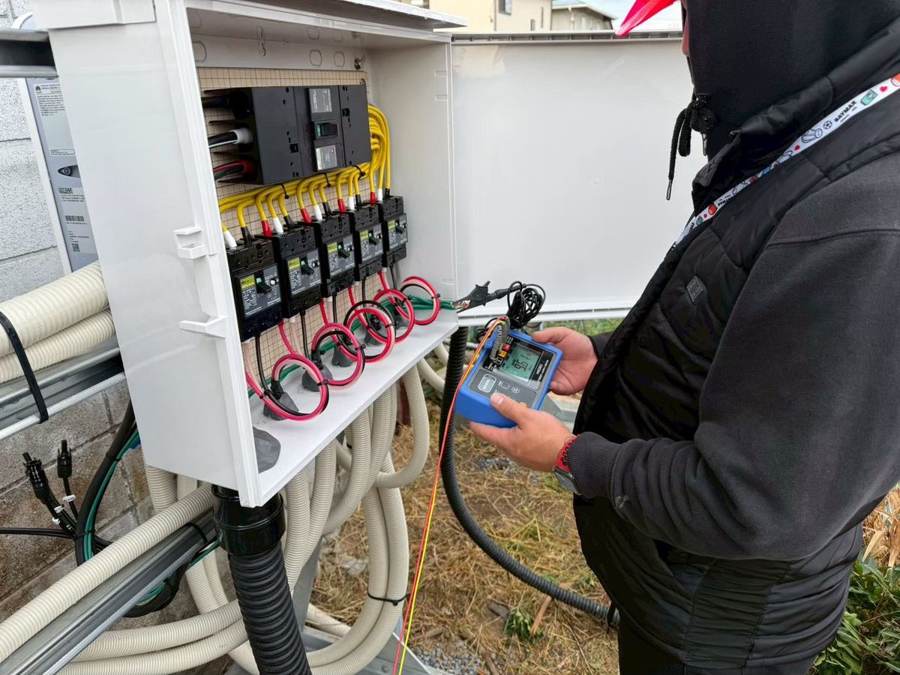 分電盤の電気設備を点検するスタッフ