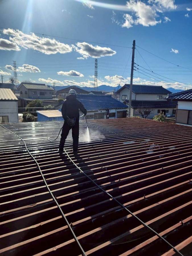 屋根を高圧洗浄するスタッフ